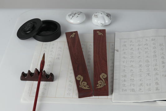 close of up traditional japanese writing instruments with brush, ink, paper weight blocks and calligraphy paper